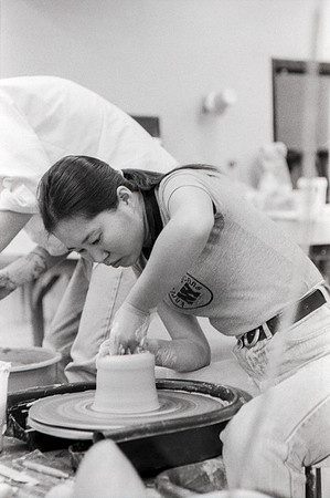 Art student works diligently on creating a piece of pottery.