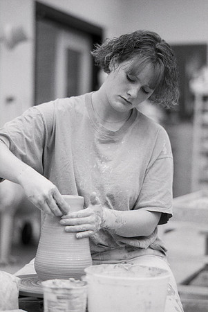 Art student works diligently on a piece of pottery for Ceramics class.