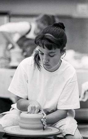Art student works diligently on a piece of pottery for Ceramics class.