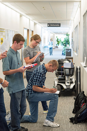 Math students working together on an assignment in the hall of the Ricks Building.