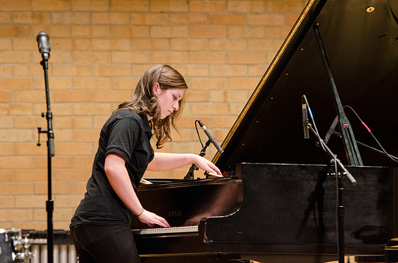 Student playing the piano (keys &amp; strings) at the RixStix concert, Spring 2013