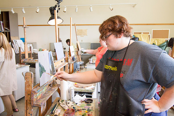 A student in Brother Bodily's Painting class begins to paint a beautiful landcape in the Spori Building.