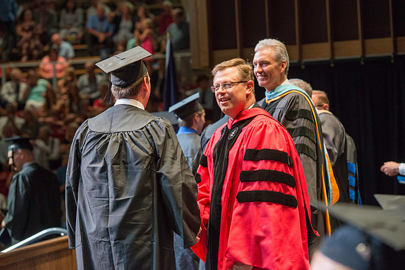 Elder Devin G Durrant and President Clark G Gilbert congratulate graduates.