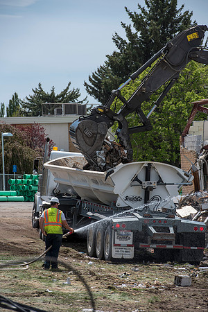 Construction workers work at tearing down the old campus dorms for a new campus project.