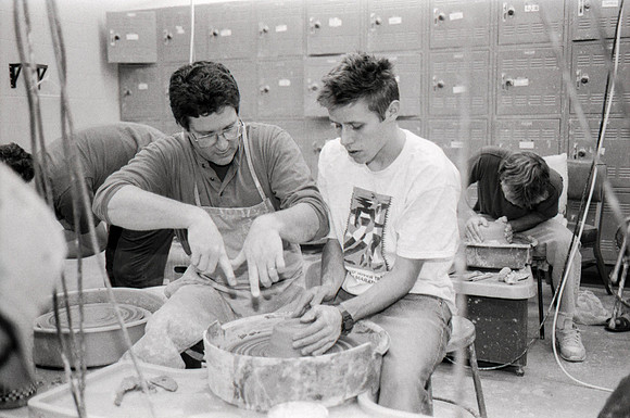Rich Briggs helps a student as creates his piece of pottery.
