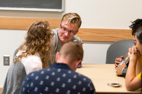 Students talk in groups about the discussion: deviating from the norm and the effect it can have on society.