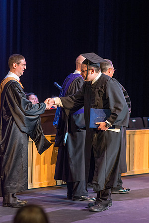 BYU-Idaho graduates accepting their diploma covers at convocation for the College of Perfoming and Visual Arts. Photo by Ryan Chase