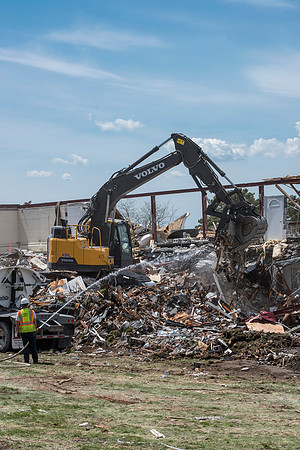 Construction workers work at tearing down the old campus dorms for a new campus project.