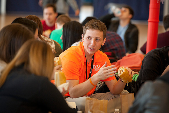 A Student Support mentor converses with new students during lunch in the I-Center.