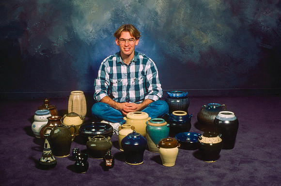 Gary Wilson, art student, shows a collection of pottery pieces.