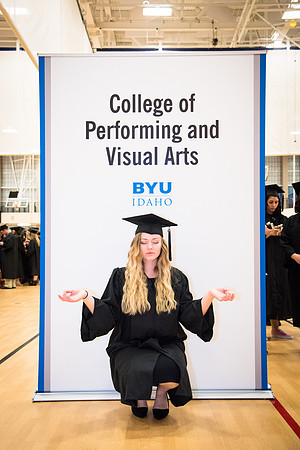 Graduate Haley Childers poses in front of a banner for her graduating college. Photo by Emily Gottfredson.