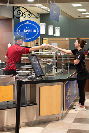 Student employee makes and serves Crepes in the Food Courts, for La Creperie