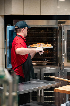 Student employee makes and serves Crepes in the Food Courts, for La Creperie