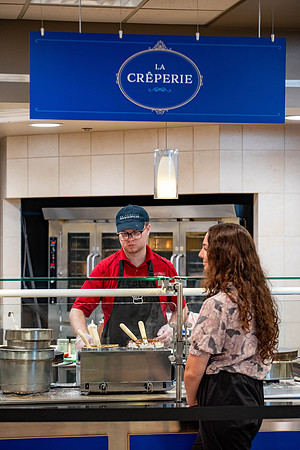 Student employee makes and serves Crepes in the Food Courts, for La Creperie