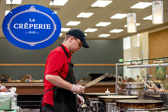 Student employee makes and serves Crepes in the Food Courts, for La Creperie