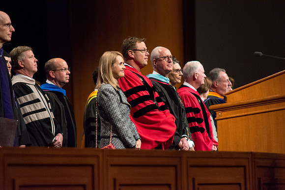 President Clark G. Gilbert stands with his wife, Christine, and Elder Larry Y. Wilson, General Authority Seventy, as they welcome in the graduates. Photo by Courtney Thomas.