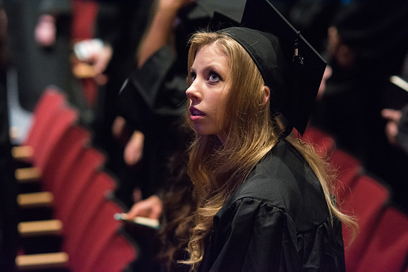 A graduate waits for Commencement to begin.