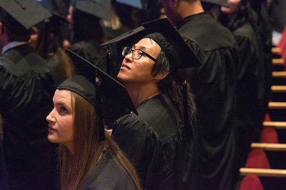 A graduate waits for Commencement to begin.