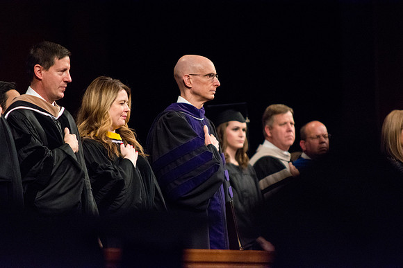 President Henry J. Eyring on the stand at Commencement while the flag is being posted.
