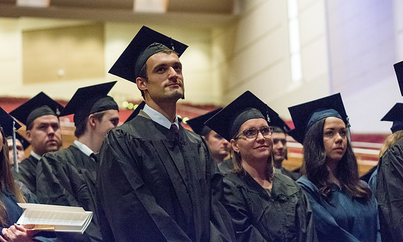 Students stand as the President presents the Graduates.