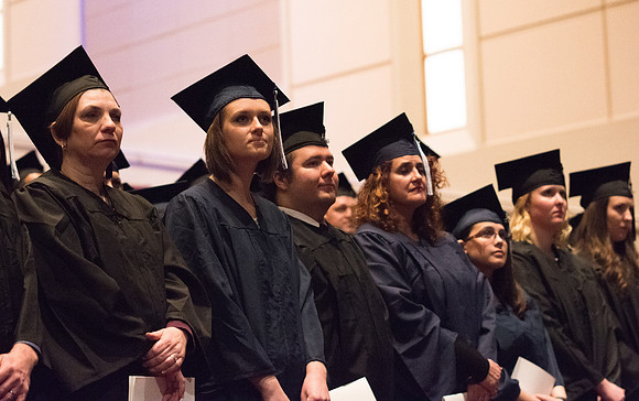 Graduates stand as President Clark G. Gilbert pronounces them as graduates.