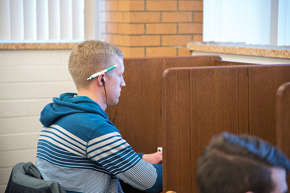 Student, Isaac Beus, gets back to studying in the Library.