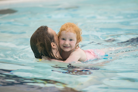 A family enjoys time together in the pool.