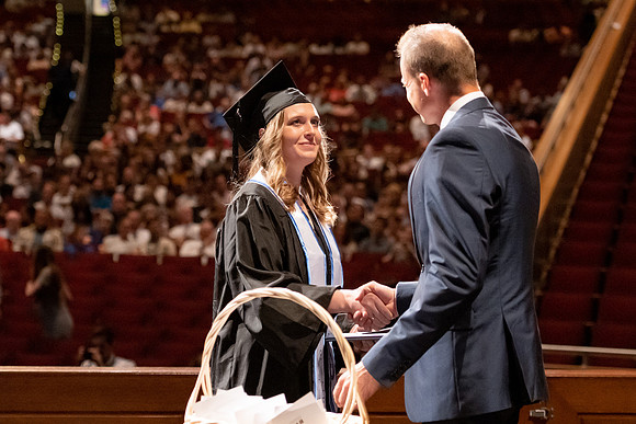 Graduates walk across the stage at the BYU-Idaho Center as they accept their diplomas for Agriculture and Life Science.