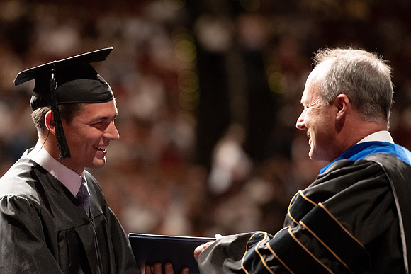 Graduates walk across the stage at the BYU-Idaho Center as they accept their diplomas for Agriculture and Life Science.