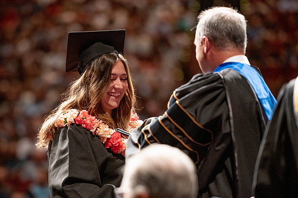 Graduates walk across the stage at the BYU-Idaho Center as they accept their diplomas for Agriculture and Life Science.