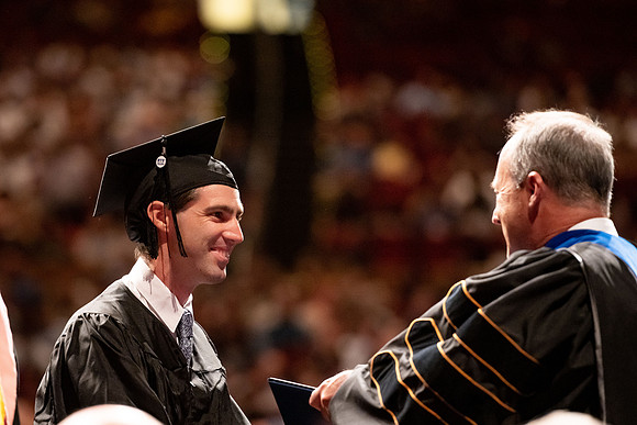 Graduates walk across the stage at the BYU-Idaho Center as they accept their diplomas for Agriculture and Life Science.