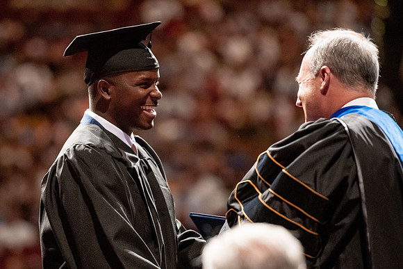 Graduates walk across the stage at the BYU-Idaho Center as they accept their diplomas for Agriculture and Life Science.