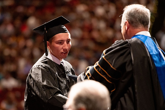 Graduates walk across the stage at the BYU-Idaho Center as they accept their diplomas for Agriculture and Life Science.