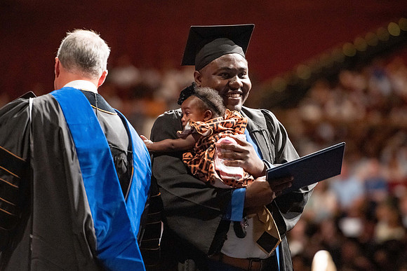 Graduates walk across the stage at the BYU-Idaho Center as they accept their diplomas for Agriculture and Life Science.
