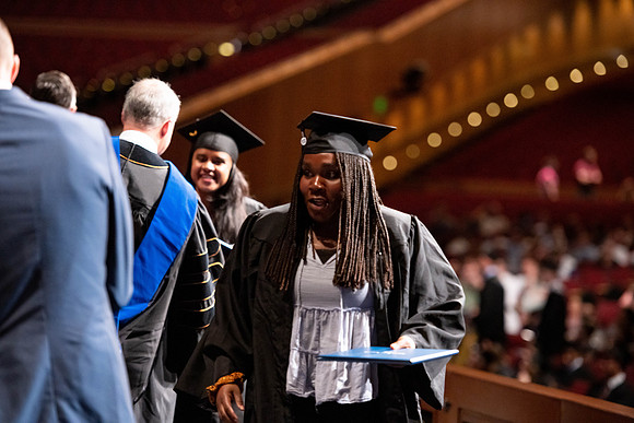 Graduates walk across the stage at the BYU-Idaho Center as they accept their diplomas for Agriculture and Life Science.