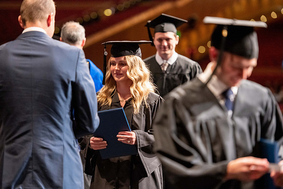 Graduates walk across the stage at the BYU-Idaho Center as they accept their diplomas for Agriculture and Life Science.