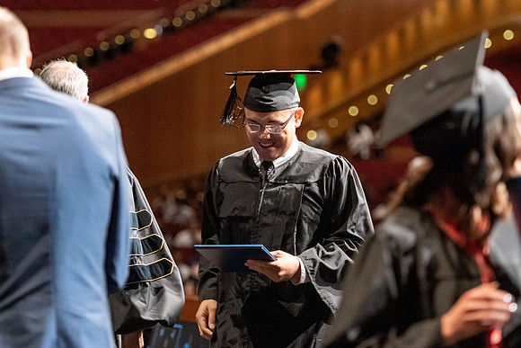 Graduates walk across the stage at the BYU-Idaho Center as they accept their diplomas for Agriculture and Life Science.