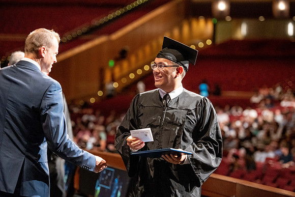 Graduates walk across the stage at the BYU-Idaho Center as they accept their diplomas for Agriculture and Life Science.