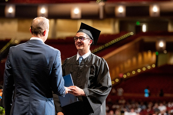 Graduates walk across the stage at the BYU-Idaho Center as they accept their diplomas for Agriculture and Life Science.