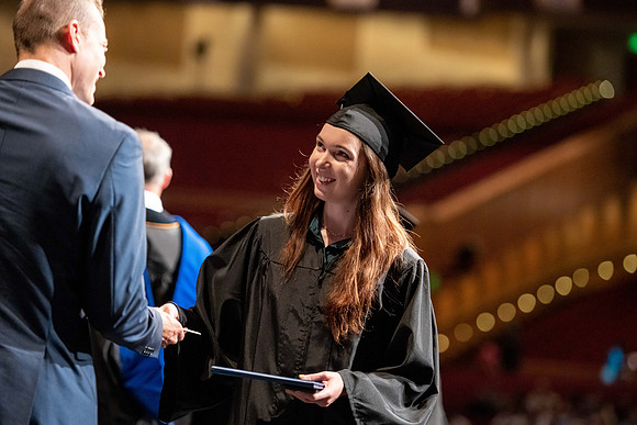 Graduates walk across the stage at the BYU-Idaho Center as they accept their diplomas for Agriculture and Life Science.