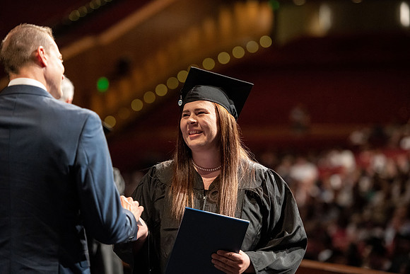 Graduates walk across the stage at the BYU-Idaho Center as they accept their diplomas for Agriculture and Life Science.