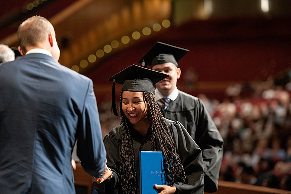 Graduates walk across the stage at the BYU-Idaho Center as they accept their diplomas for Agriculture and Life Science.