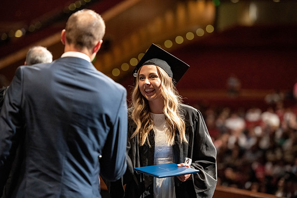 Graduates walk across the stage at the BYU-Idaho Center as they accept their diplomas for Agriculture and Life Science.