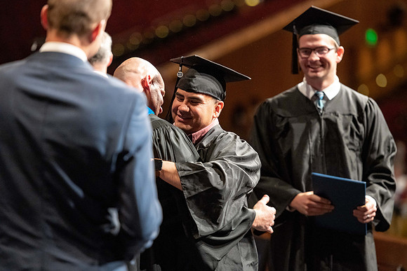 Graduates walk across the stage at the BYU-Idaho Center as they accept their diplomas for Agriculture and Life Science.