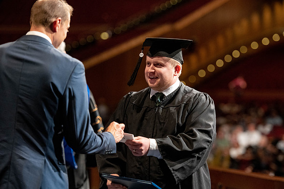 Graduates walk across the stage at the BYU-Idaho Center as they accept their diplomas for Agriculture and Life Science.