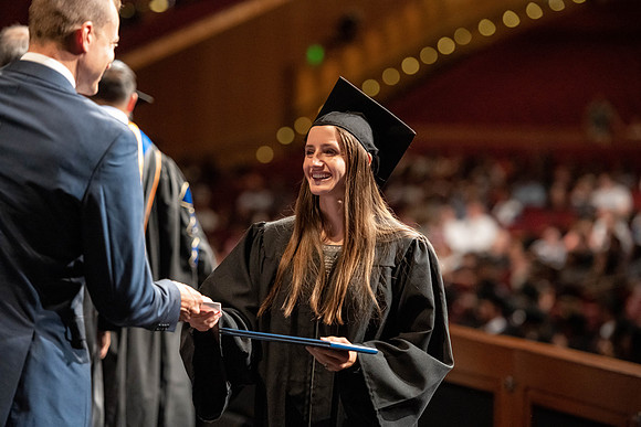 Graduates walk across the stage at the BYU-Idaho Center as they accept their diplomas for Agriculture and Life Science.