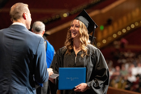 Graduates walk across the stage at the BYU-Idaho Center as they accept their diplomas for Agriculture and Life Science.