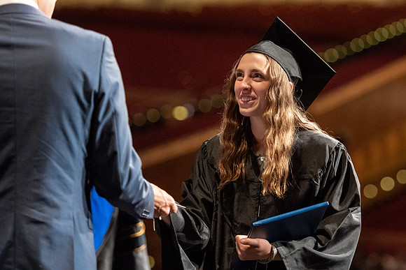 Graduates walk across the stage at the BYU-Idaho Center as they accept their diplomas for Agriculture and Life Science.