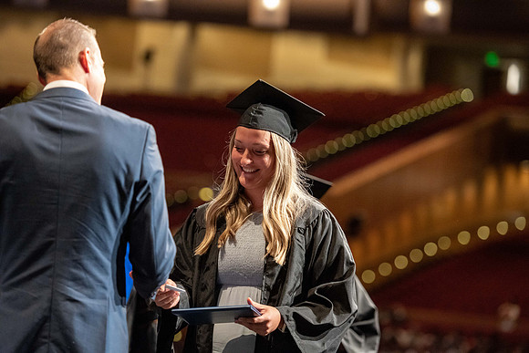 Graduates walk across the stage at the BYU-Idaho Center as they accept their diplomas for Agriculture and Life Science.