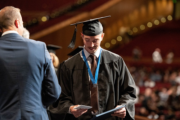 Graduates walk across the stage at the BYU-Idaho Center as they accept their diplomas for Agriculture and Life Science.